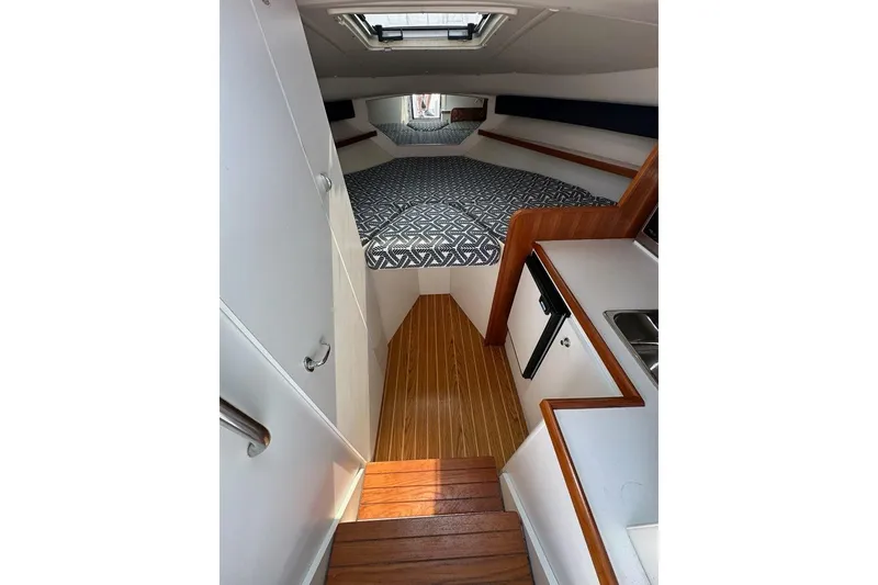Slide: The Image of Interior of 2006 Tiara Yachts 2900 Coronet, featuring wood flooring and compact kitchenette. - 11