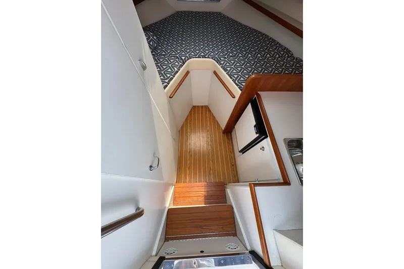 Slide: The Image of 2006 Tiara Yachts 2900 Coronet interior with wood flooring and patterned bedding. - 13