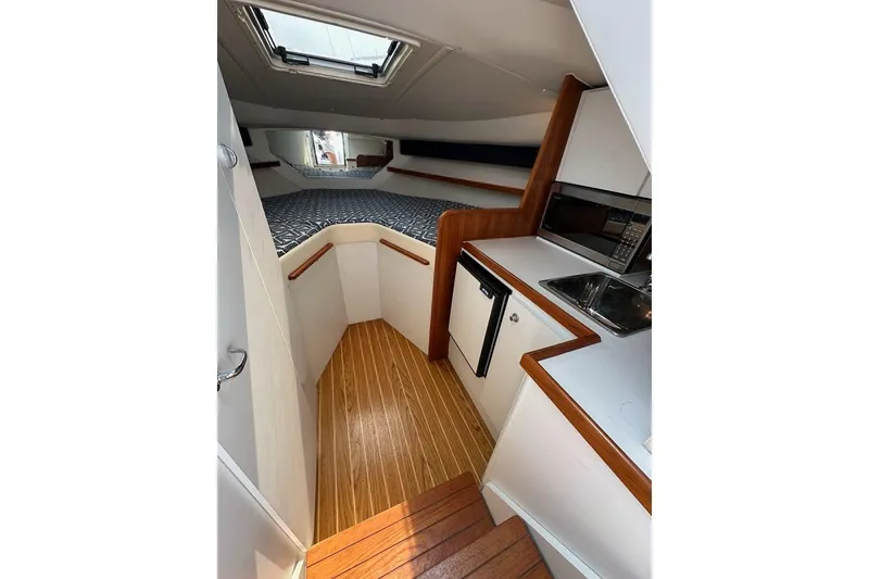 Slide: The Image of 2006 Tiara Yachts 2900 Coronet interior with kitchenette and cozy sleeping area. - 14