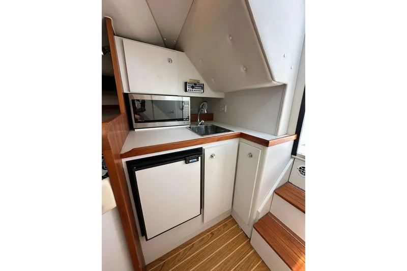 Slide: The Image of 2006 Tiara Yachts 2900 Coronet galley with microwave, sink, and compact fridge. - 15