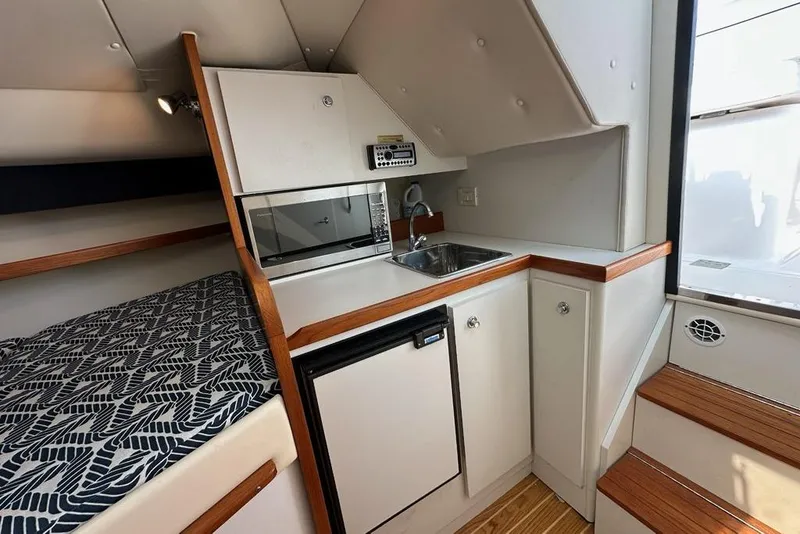 Slide: The Image of 2006 Tiara Yachts 2900 Coronet interior with kitchenette, sink, and patterned bedding. - 16