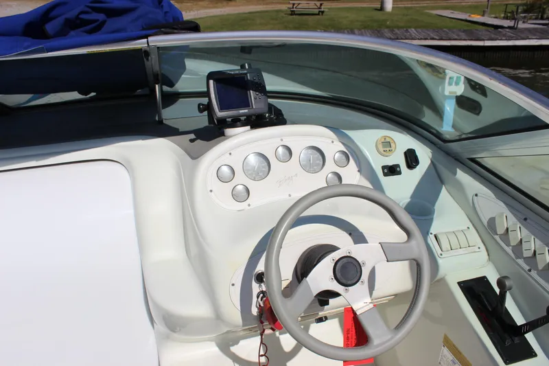 Slide: The Image of 1995 Baja 272 boat dashboard with steering wheel and navigation equipment. - 13