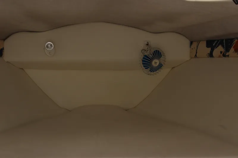 Slide: The Image of Interior of a 1995 Baja 272 boat, featuring beige upholstery and a small fan. - 21