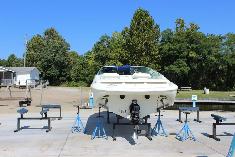 Slide: The Image of 1995 Baja 272 boat on stands, outdoor setting with trees and clear sky. - 3
