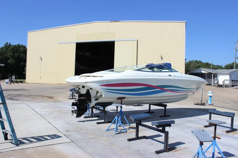 Slide: The Image of 1995 Baja 272 boat on stands outside a large warehouse. - 6