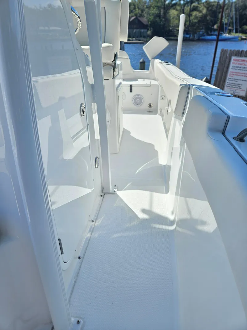 Slide: The Image of 2026 Sea Hunt Ultra 234 boat interior with sleek white design and waterfront view. - 18