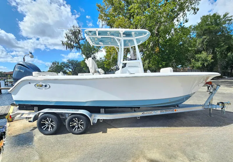 Slide: The Image of 2026 Sea Hunt Ultra 234 boat on trailer, parked outdoors under a blue sky. - 2