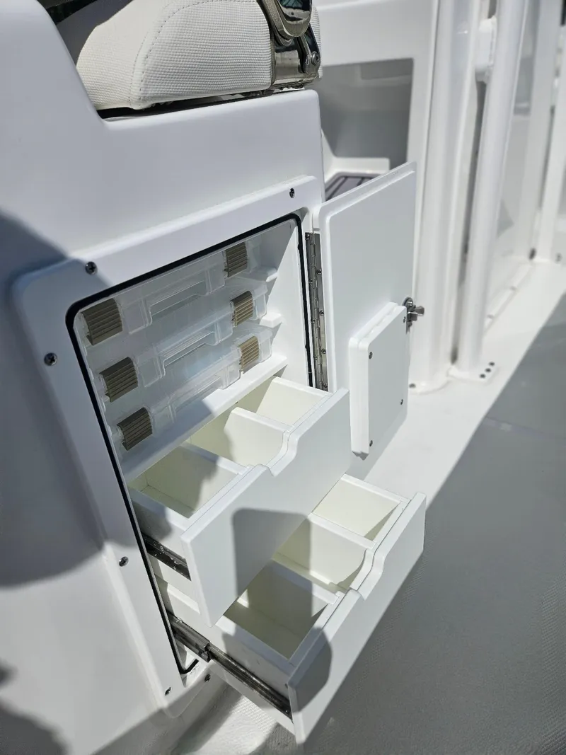 Slide: The Image of 2026 Sea Hunt Ultra 234 boat storage compartments with open drawers and sleek design. - 26