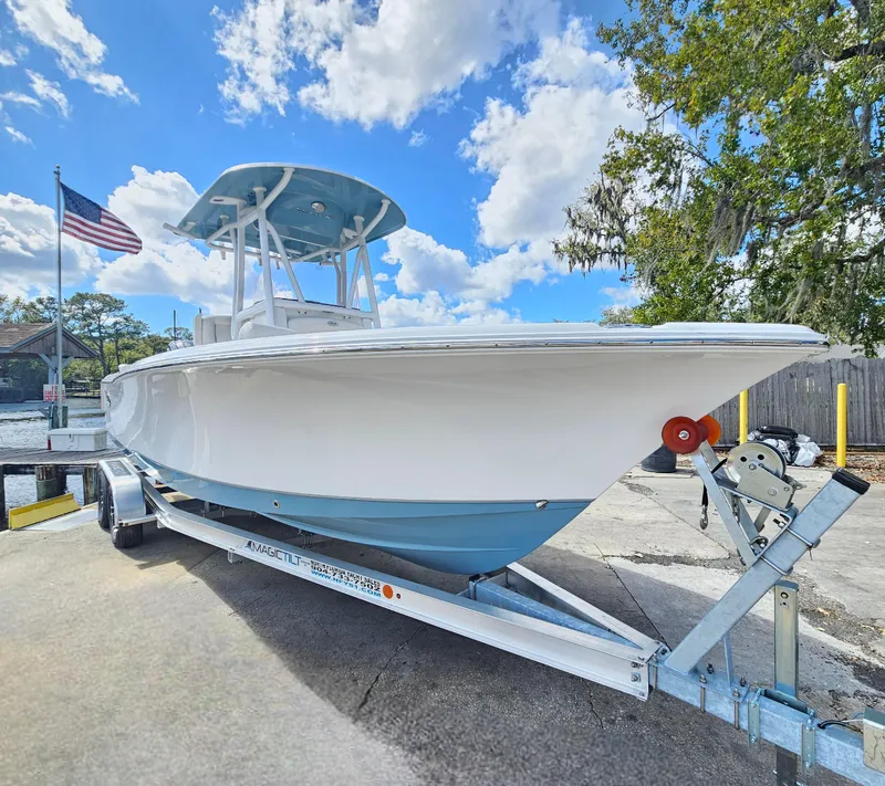 Slide: The Image of 2026 Sea Hunt Ultra 234 boat on trailer, under blue sky with American flag. - 7