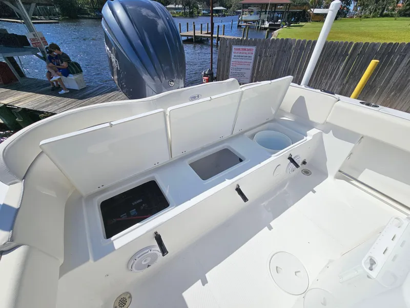 Slide: The Image of 2026 Sea Hunt Ultra 234 boat interior with open storage compartments by the water. - 29