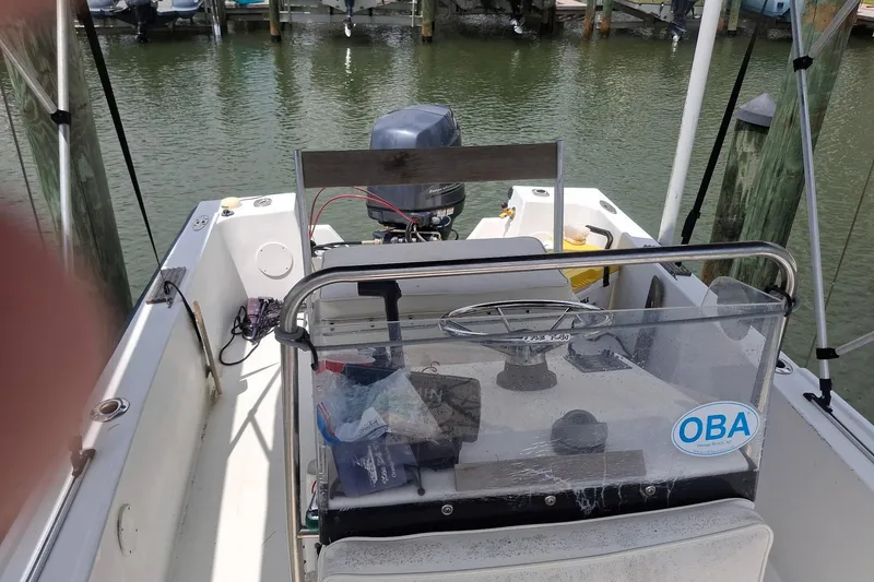 Slide: The Image of 1989 Mako 171 Center Console boat docked, featuring steering console and outboard motor. - 4