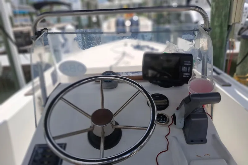 Slide: The Image of 1989 Mako 171 Center Console boat dashboard with steering wheel and navigation equipment. - 6