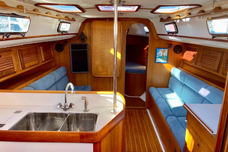 Slide: The Image of Interior of a 1995 Freedom 35 sailboat with wood finish and blue seating. - 13