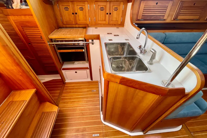 Slide: The Image of 1995 Freedom 35 yacht interior with wooden cabinetry, dual sink, and compact kitchen area. - 15