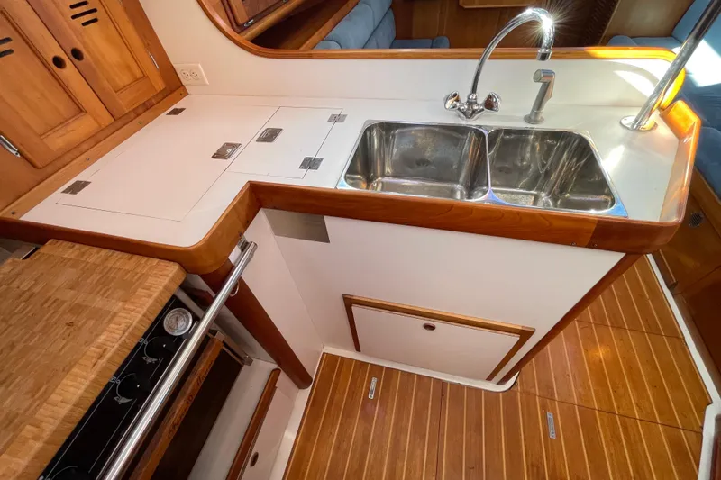 Slide: The Image of Galley kitchen in 1995 Freedom 35 sailboat with double sink and wooden cabinetry. - 17
