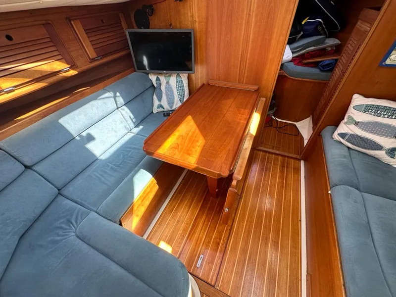 Slide: The Image of Interior of a 1995 Freedom 35 yacht with wooden table and blue cushions. - 21