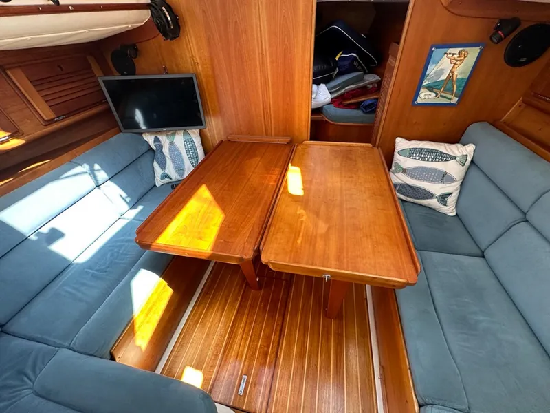 Slide: The Image of Interior of a 1995 Freedom 35 yacht with wooden table and blue cushions. - 22