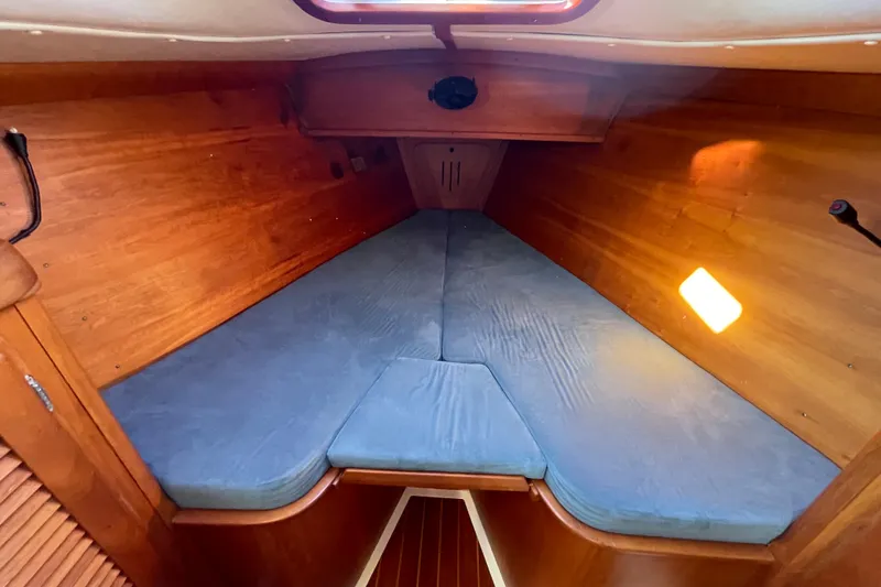 Slide: The Image of Cozy cabin interior of 1995 Freedom 35 sailboat with wooden finish and blue cushions. - 23
