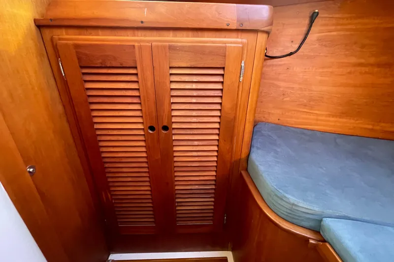 Slide: The Image of Wooden interior of 1995 Freedom 35 sailboat with louvered cabinet and cushioned seating. - 24