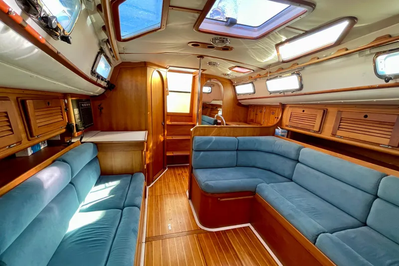 Slide: The Image of Interior of a 1995 Freedom 35 sailboat with blue seating and wooden finishes. - 26