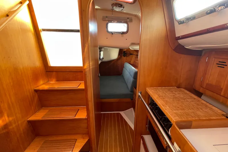 Slide: The Image of Interior of 1995 Freedom 35 sailboat with wooden cabinetry and cozy seating area. - 30