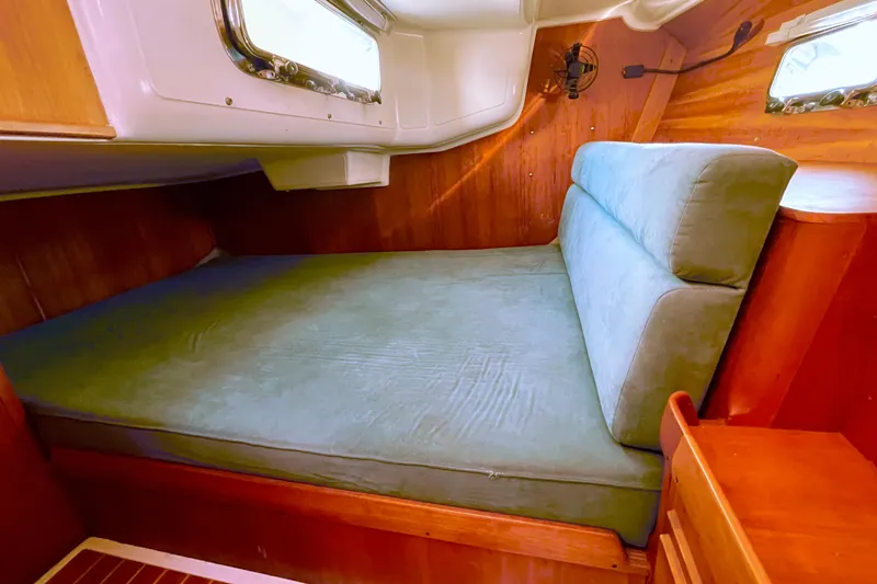 Slide: The Image of Cozy cabin interior of 1995 Freedom 35 sailboat with cushioned seating and wooden accents. - 31