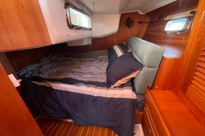 Slide: The Image of Cozy cabin interior of 1995 Freedom 35 sailboat with striped bedding and wooden accents. - 33