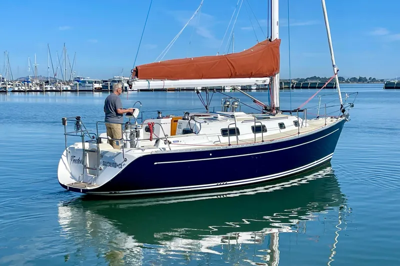 Slide: The Image of Sailboat Freedom 35, 1995 model, docked in calm marina waters under clear blue sky. - 8