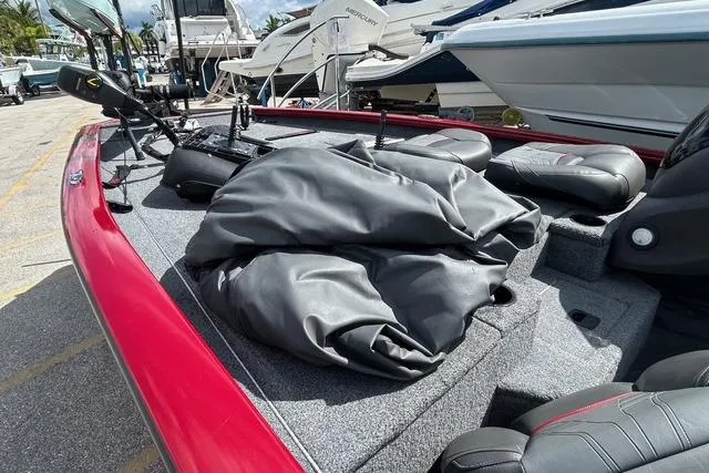 Slide: The Image of 2022 Tracker Pro Team 190 TX Tournament Edition boat with red exterior, docked at marina. - 10