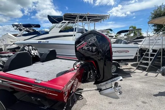 Slide: The Image of 2022 Tracker Pro Team 190 TX Tournament Edition boat with Mercury engine, docked under blue sky. - 2