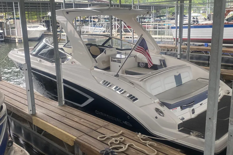 The Image of 2015 Chaparral 307 SSX boat docked, featuring sleek design and American flag. - 0