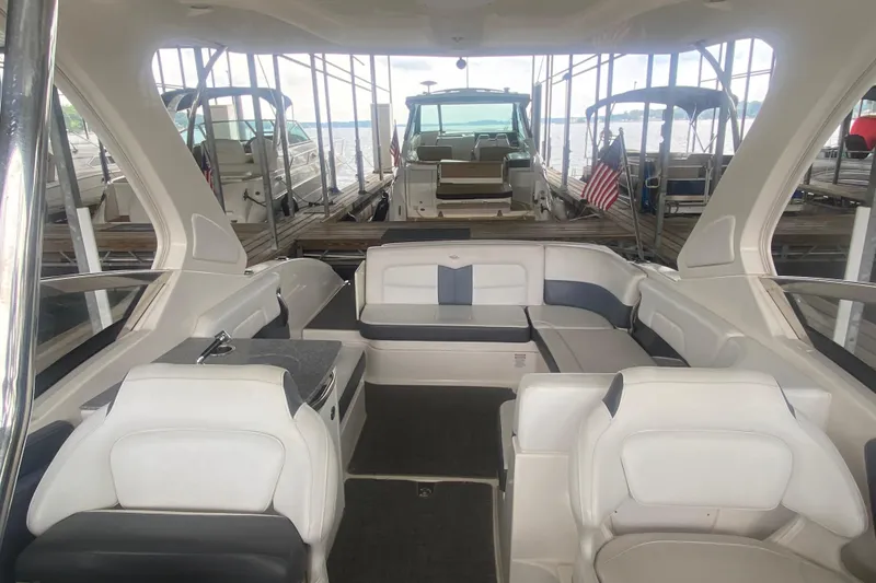 Slide: The Image of 2015 Chaparral 307 SSX boat interior with seating, docked in a marina. - 10