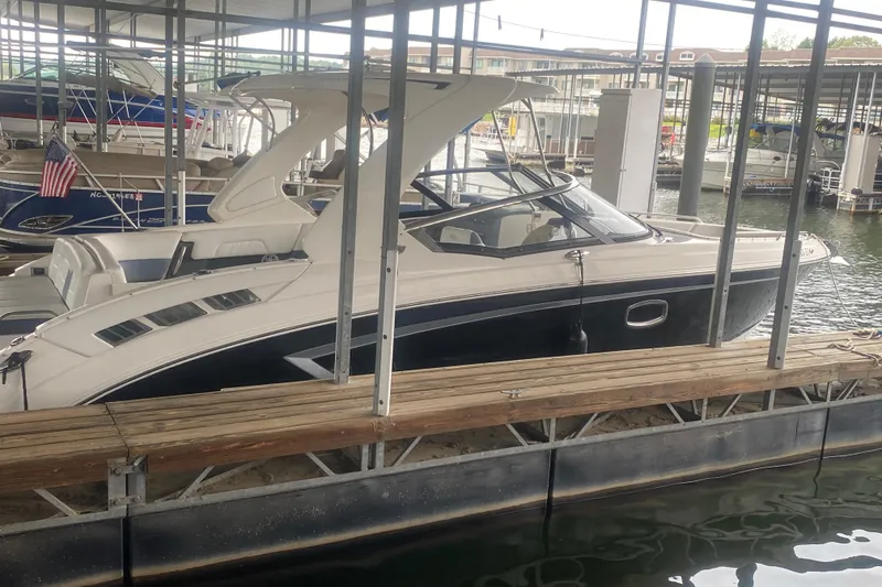 Slide: The Image of 2015 Chaparral 307 SSX boat docked in a marina, side view. - 2