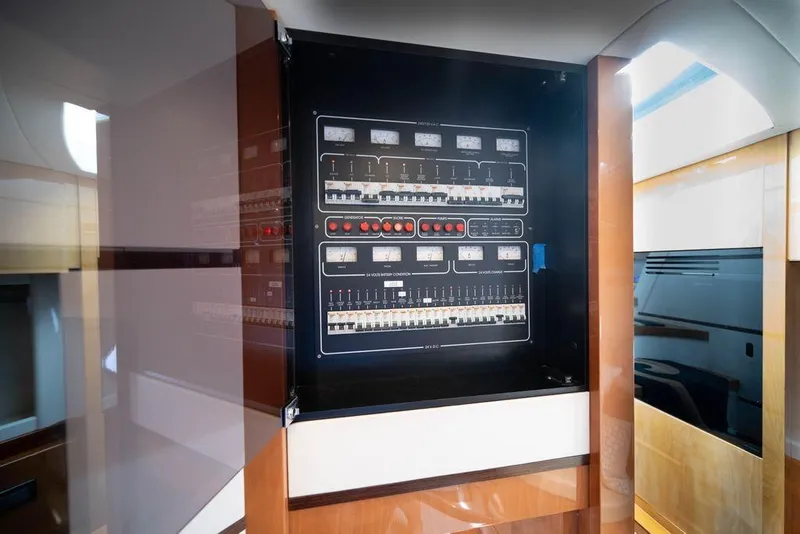Slide: The Image of Electrical control panel inside 2007 Pershing 62' yacht, featuring switches and meters. - 18