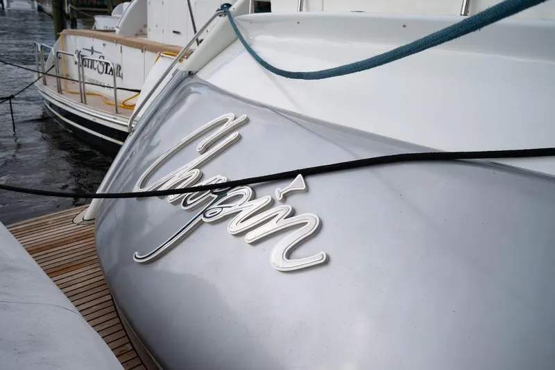 Slide: The Image of 2007 Pershing 62' yacht with "Chopin" nameplate, docked beside another vessel. - 20