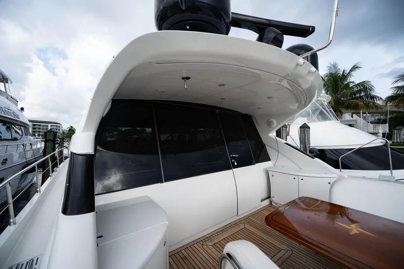 Slide: The Image of 2007 Pershing 62' yacht with sleek design, docked near palm trees and other boats. - 38