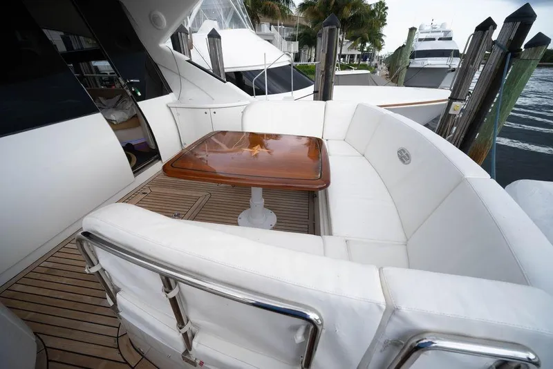 Slide: The Image of Luxurious 2007 Pershing 62' yacht with elegant white seating and wooden table on deck. - 5