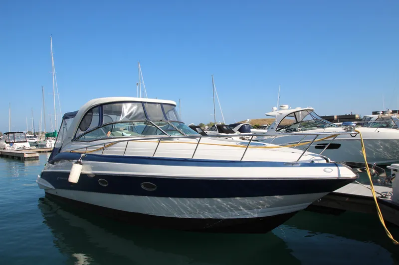 The Image of 2008 Crownline 340 CR boat docked in marina under clear blue sky. - 0