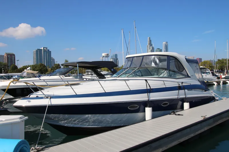 Slide: The Image of 2008 Crownline 340 CR yacht docked at marina with city skyline in background. - 2