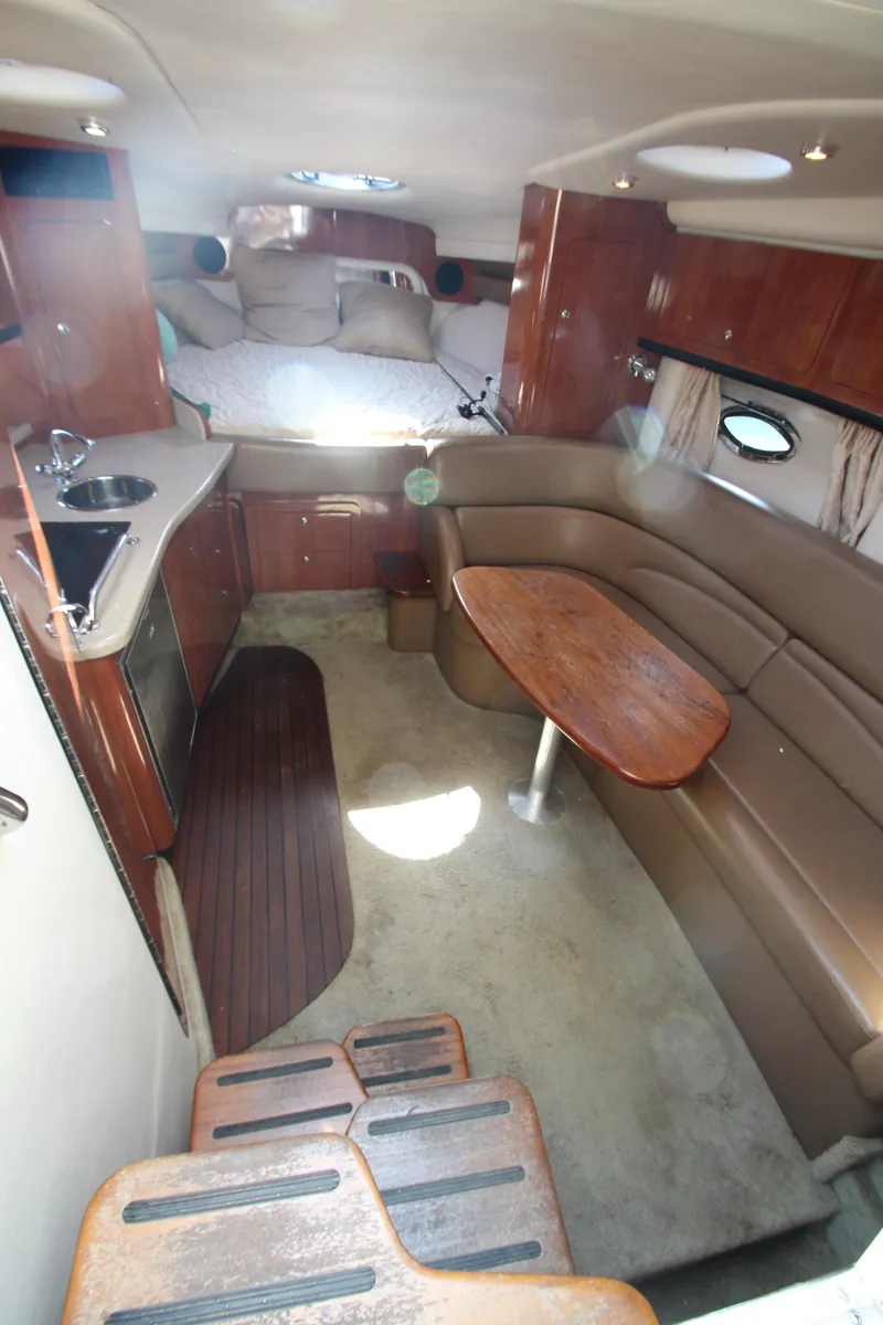 Slide: The Image of 2008 Crownline 340 CR cabin interior with kitchenette, seating area, and bed. - 23