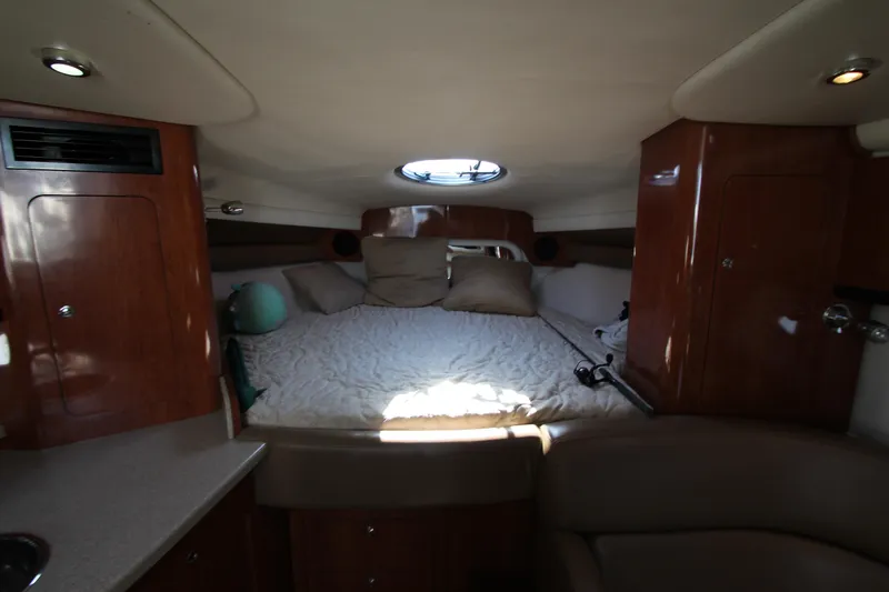 Slide: The Image of Interior cabin of 2008 Crownline 340 CR boat with bed and wooden cabinetry. - 28