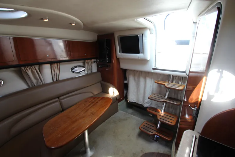 Slide: The Image of Interior of 2008 Crownline 340 CR yacht with seating, table, and wooden steps. - 30