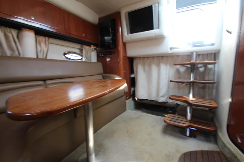 Slide: The Image of 2008 Crownline 340 CR cabin interior with wooden table, seating, and stairs. - 31