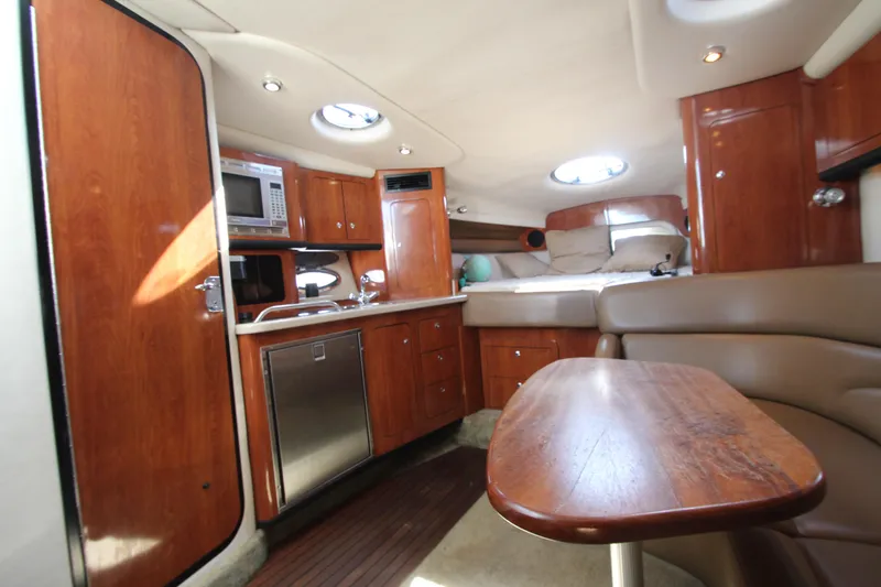 Slide: The Image of 2008 Crownline 340 CR cabin interior with wood finish, kitchenette, and seating area. - 35