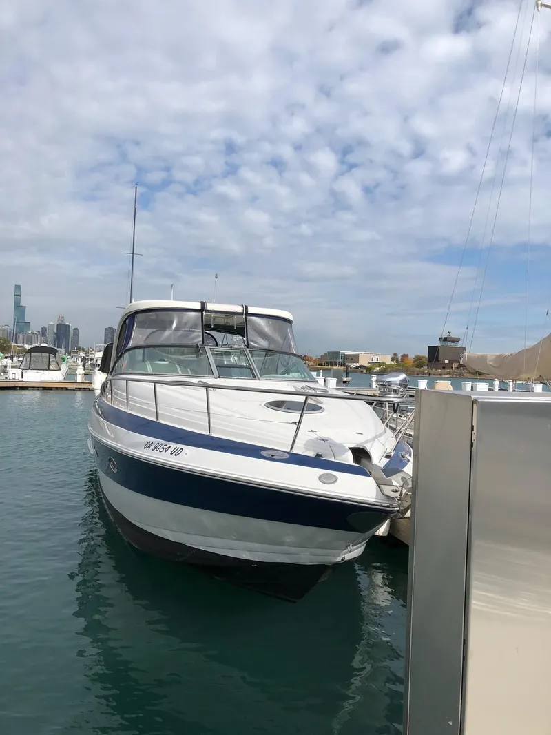 Slide: The Image of 2008 Crownline 340 CR boat docked in a marina under a cloudy sky. - 6