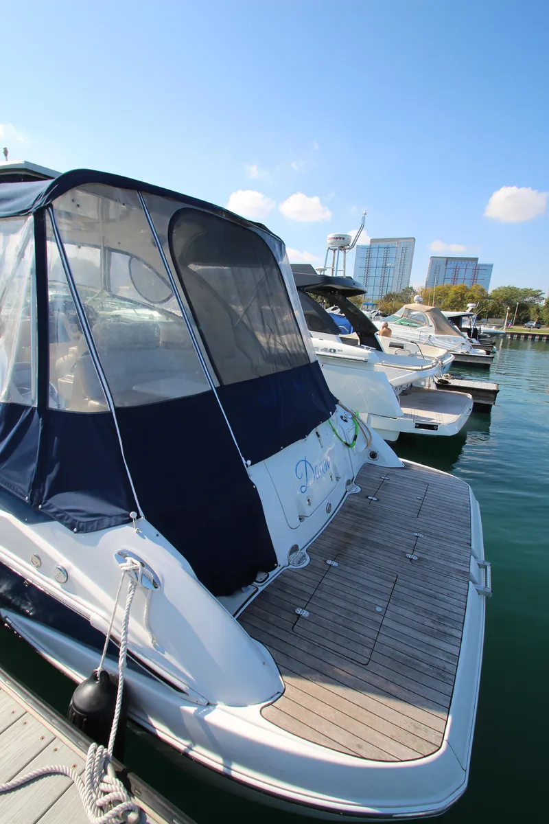Slide: The Image of 2008 Crownline 340 CR boat docked in marina, clear sky, modern buildings in background. - 7