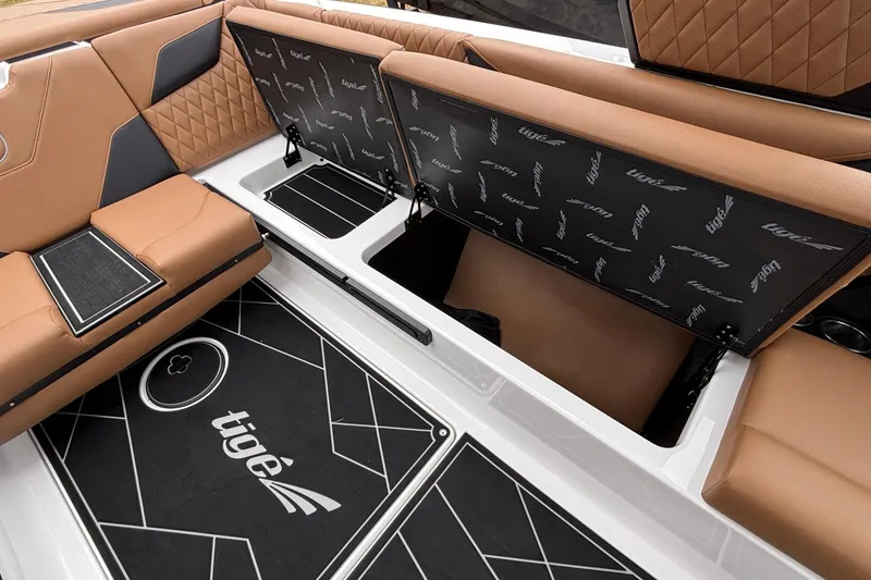 Slide: The Image of 2026 Tigé Z5 boat interior with tan seating and storage compartments open. - 28