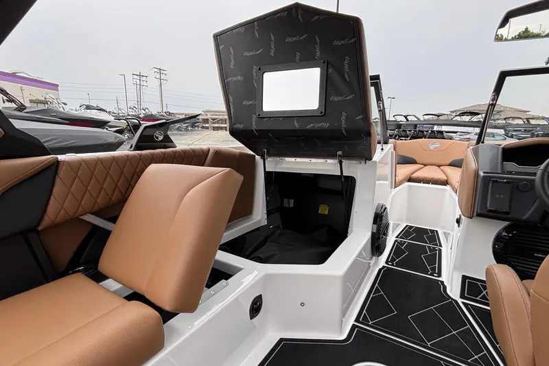 Slide: The Image of 2026 Tigé Z5 boat interior with tan seating and open storage compartment. - 31
