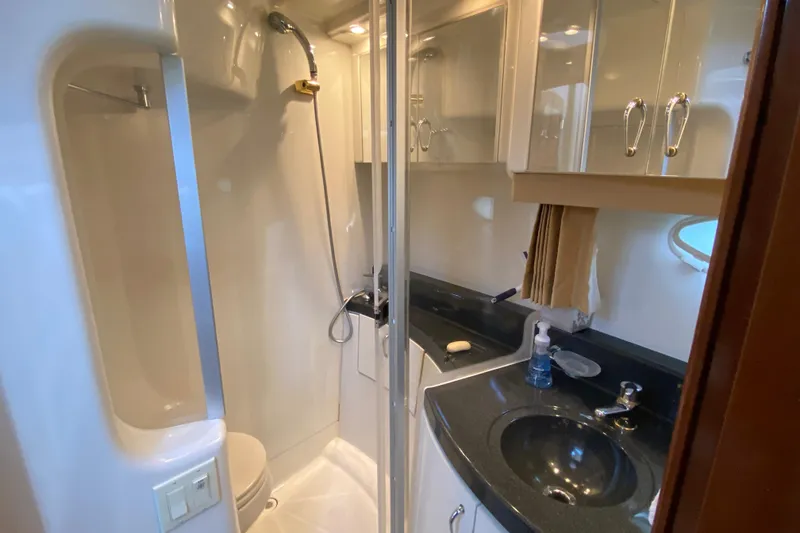 Slide: The Image of 2004 Carver 36 Super Sport yacht bathroom with shower, sink, and storage cabinets. - 27