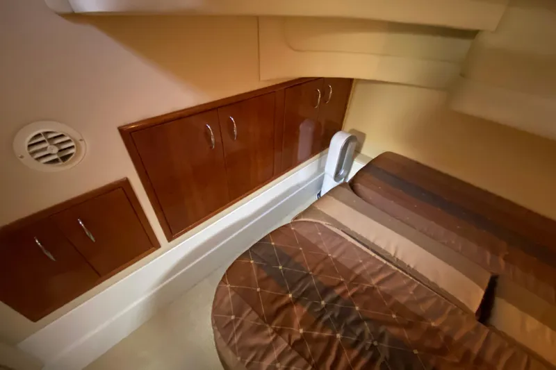 Slide: The Image of 2004 Carver 36 Super Sport cabin interior with wood cabinets and striped bedding. - 33
